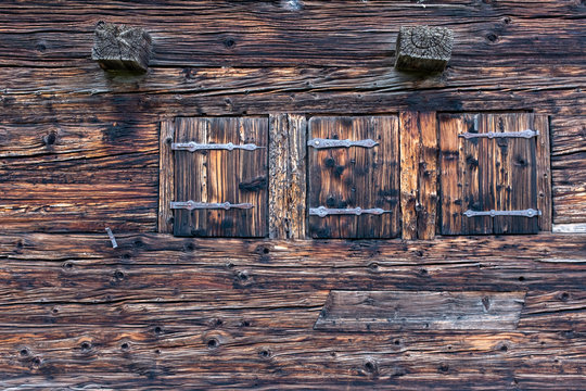 Three closed windows with shutters on an old Swiss farm house