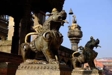 Lion on Bhaktapur Durbar Square with Hindu shrine and temple, Bhaktapur, Nepal