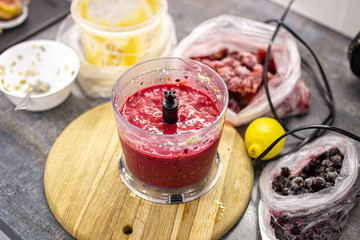 berry-fruit smoothie in a blender, preparing a dessert.