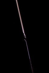 screwdriver tightens a screw. on a black background in backlight.