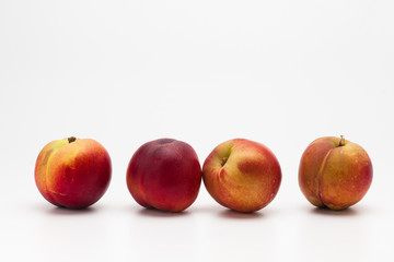Row of Heavenly ripe peaches on white 