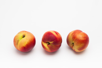 Row of Heavenly ripe peaches on white 