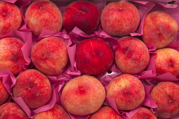Pile of ripe peaches on a box 