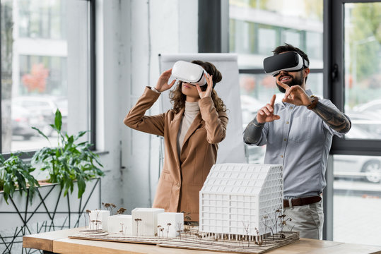 smiling virtual reality architects in virtual reality headsets pointing with finger - Powered by Adobe