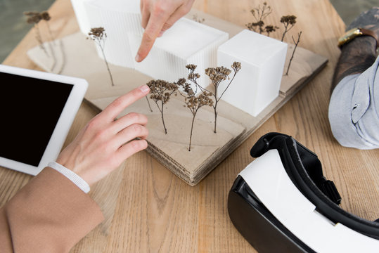 cropped view of virtual reality architects pointing with fingers at model of house - Powered by Adobe