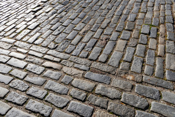 Close up detail showing granite setts or cobblestone, a hardscape materials used in the construction of roads, sidewalks and driveways in the historic district of Charleston, South Carolina.  