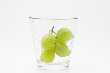  Fresh green grapes with glass cup isolated 
