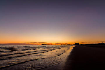 Fototapeta na wymiar Orange sunrise on the beach in Puerto Madryn, Patagonia, Argentina