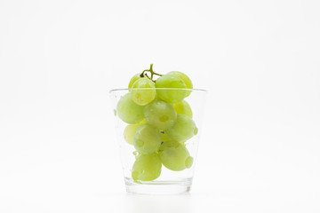  Fresh green grapes with glass cup isolated 