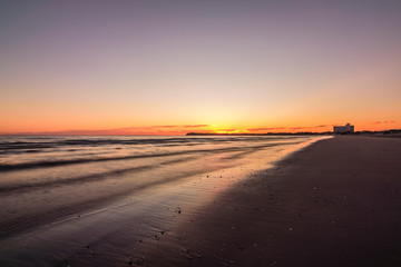 Fototapeta na wymiar Orange sunrise on the beach in Puerto Madryn, Patagonia, Argentina