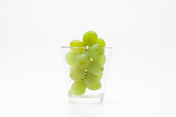  Fresh green grapes with glass cup isolated 