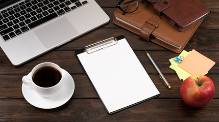 .laptop, coffee and notebooks on a wooden background