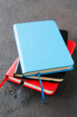 Stack of colorful notebooks for writing or books on dark background