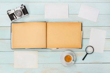 Old photo album with photos on a  wooden table and old cameras.Mockup free.Copy space.