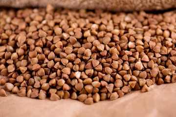 Scattered buckwheat on a brown kraft paper background. Close-up buckwheat.