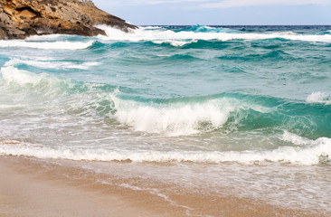 Sandy coast with rocks and waves