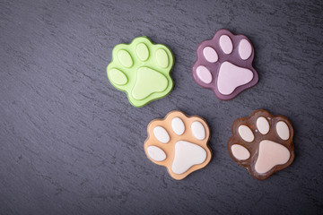Cute colored paw shape soap on dark dark background. Dark background