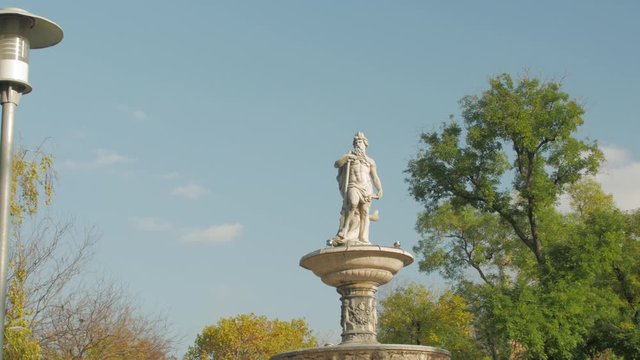 Statue of Danubius fountain old light shadow Elizabeth square Erzsebet teri park on Sunset in Budapest Hungary push in dolly camera movement