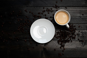 Kaffeetasse mit Untertasse und Kaffeebohnen