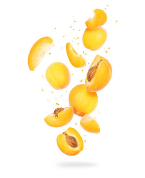 Fresh whole and sliced fresh apricots in the air on a white background