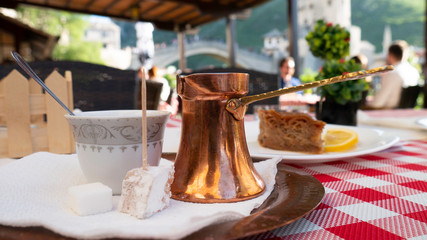 Traditional Turkish coffee and turkish delight. View of Mostar Old bridge in the background, Bosnia and Herzegovina. 