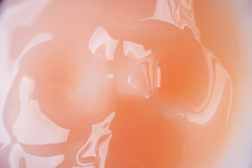 Fototapeta premium Texture of liquid cream in a pink jar. Cosmetic background. Macro.