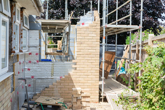 Renovation projects. Building of extension of the existing house, finished brick walls, scaffoliding, selective focus