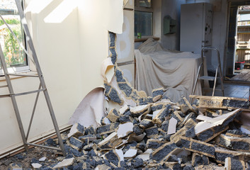 Indoor renovation project, demolition of the wall between two rooms, damaged block wall, selective focus