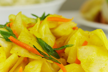 Sauerkraut with carrots, turmeric and green onions, side view from above