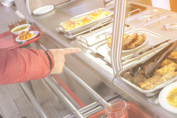 set with dishes and food on a tray in a public dining room, front and background blurred with a...