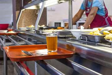 set with dishes and food on a tray in a public dining room, front and background blurred with a bokeh effect