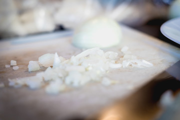 woman cuts onions on a white plastic board