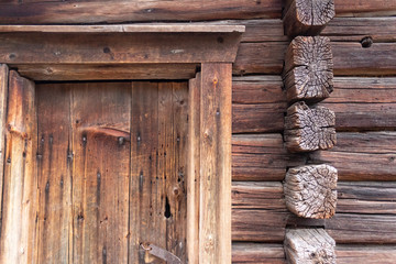 Fragment of a door and walls of an ancient authentic wooden house of the 17th century in a forest on the island of Seurasaari in Helsinki, Finland, a cloudy day in late autumn. The harsh beauty of anc