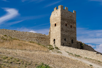 Fototapeta na wymiar Scenic view of fortification walls of medieval Genoese fortress on Black Sea coast in the southern part of Feodosia city. Feodosia, Crimea, Russia - September, 2019