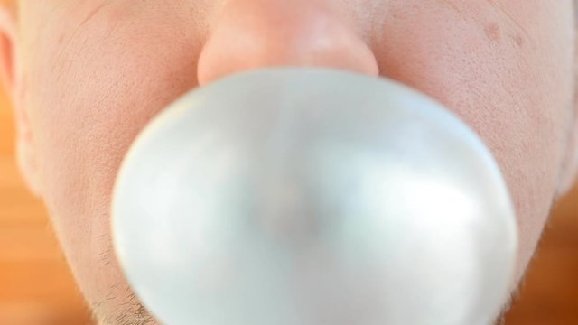 man blowing chewing gum very big bubble