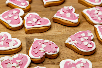 Valentine day gingerbread cookies heart with sprinkles on wooden background.