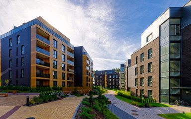 Apartment in residential building exterior. Housing structure at blue modern house of Europe. Rental home in city district on summer. Wall and glass high architecture for business property investment.