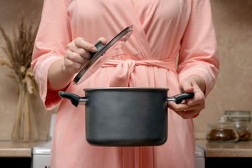 Woman is cooking food on the electric stove on home kitchen.
