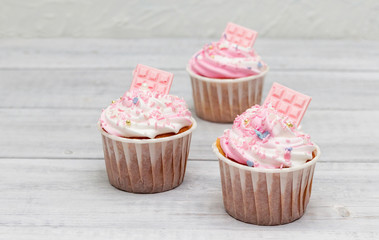Delicious cupcakes with pink and white cream.