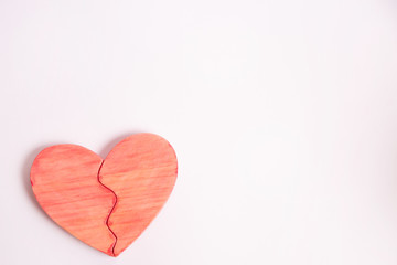 Corazón rojo de madera artesanal sobre fondo blanco.