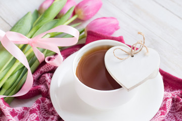 Cup of tea, wooden heart and tulips