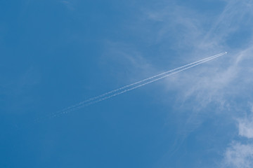 Plane in the sky. Blue background and clouds.
