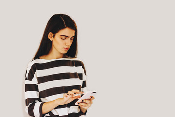 Fototapeta premium The girl is typing a message on her phone.