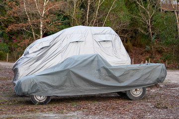 two Car underneath a car cover to protect against sun and dust