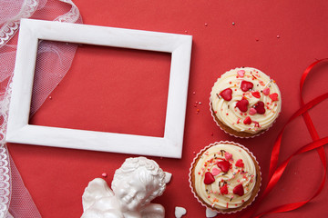 Flat composition for Valentine's Day greetings. Cupcakes, angel, frame on a red background. Copy space for your text