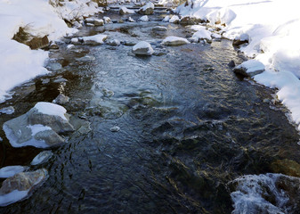 porzione di ruscello nel paesaggio innevato