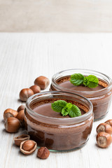 Homemade chocolate hazelnut praline in glass jar isolated on white