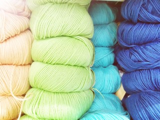 Defocused background of soft balls of wool in blue colors. The concept of coziness and comfort.