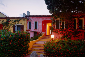 Houses at Baja Sardinia luxury resort at night in Costa Smeralda at sunset, evening, Sardegna island in Italy in summer. Olbia province