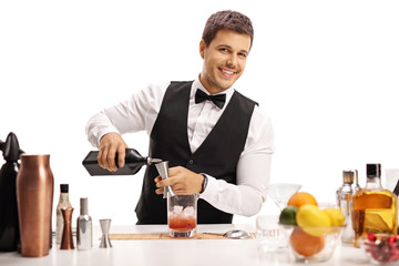 Young barman pouring a drink
